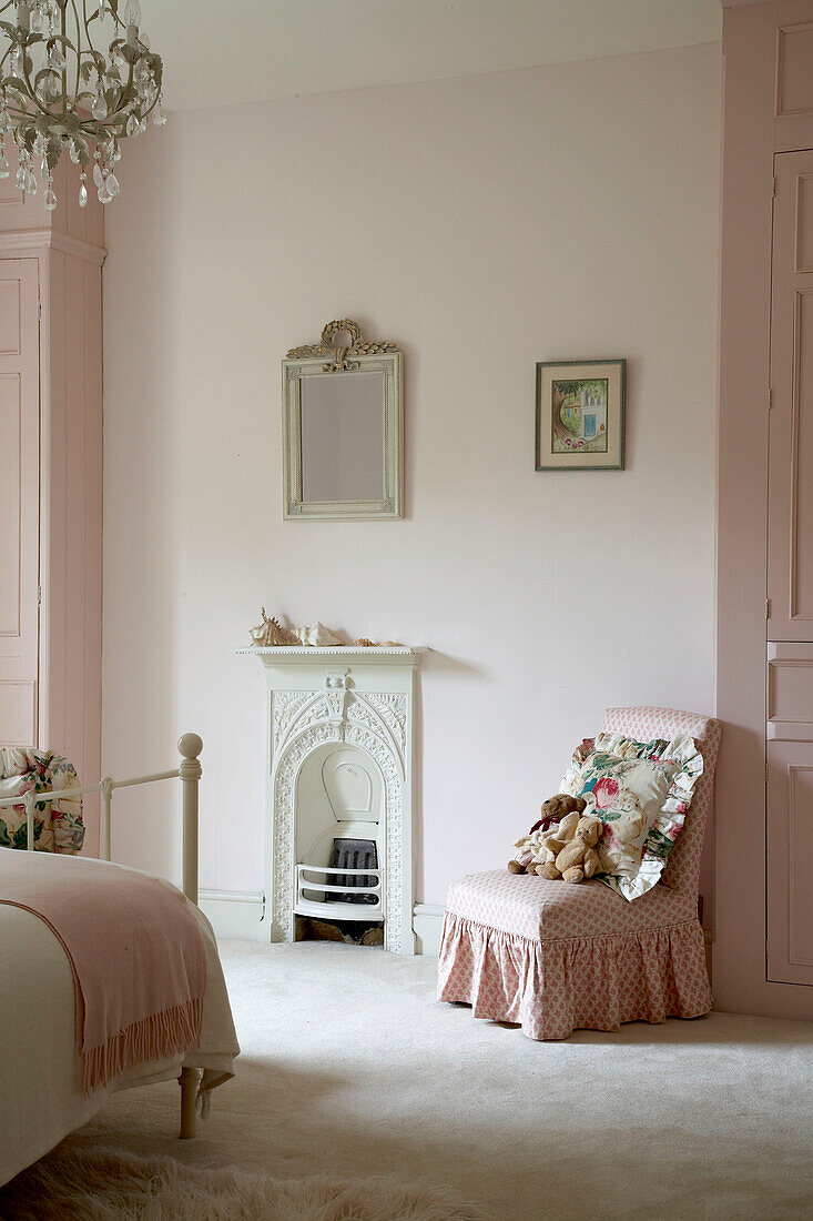 Rosa Decke auf einem Bett mit gepolstertem Stuhl in einem Schlafzimmer, Arundel, West Sussex