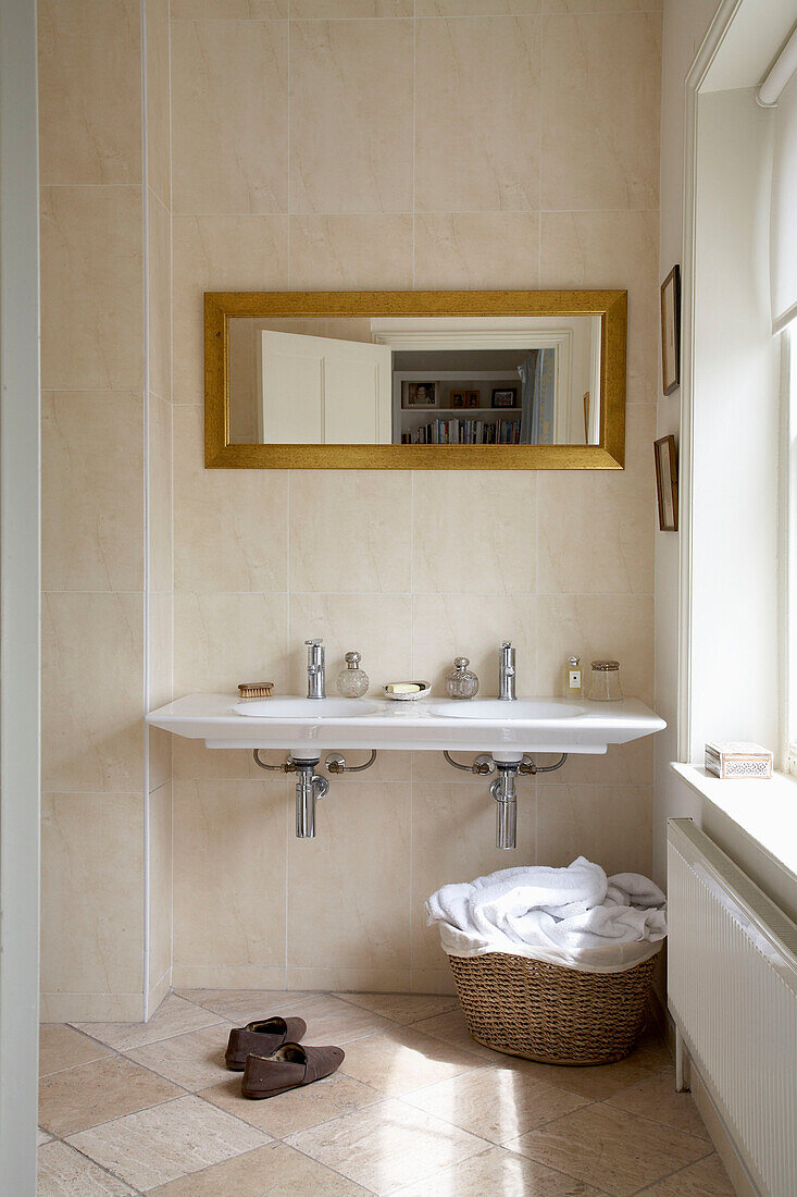 Spiegel über Doppelwaschbecken mit Wäschekorb in Badezimmer, Arundel, West Sussex