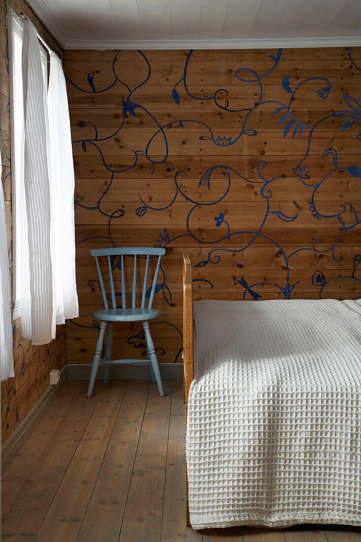 Simple blue chair next to double bed in country style bedroom