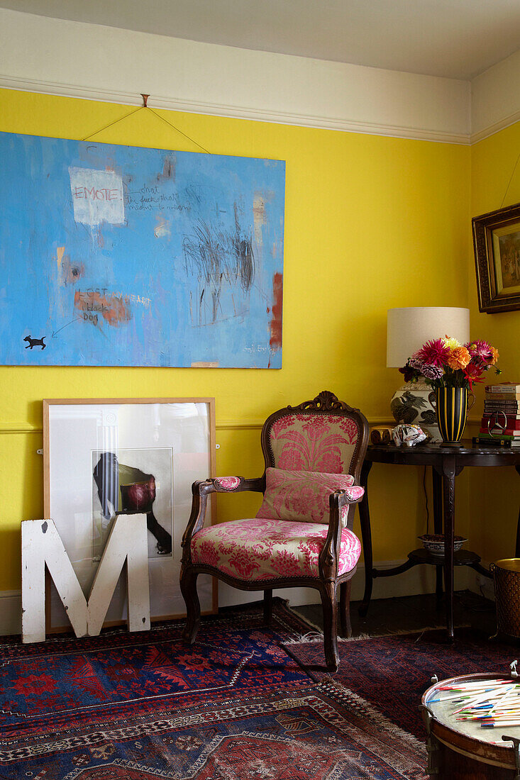 Modern artwork in yellow room with patterned rug