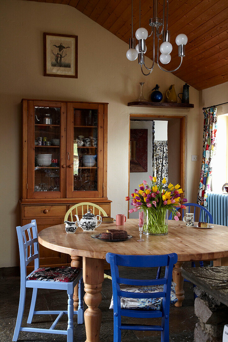 Küchenkommode aus Holz und Tisch mit verschiedenen Stühlen