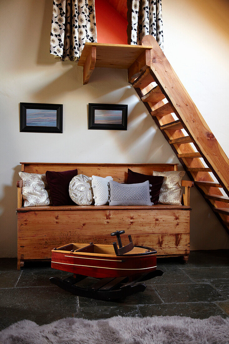 Open stairs in a room with pine bench and slate floor