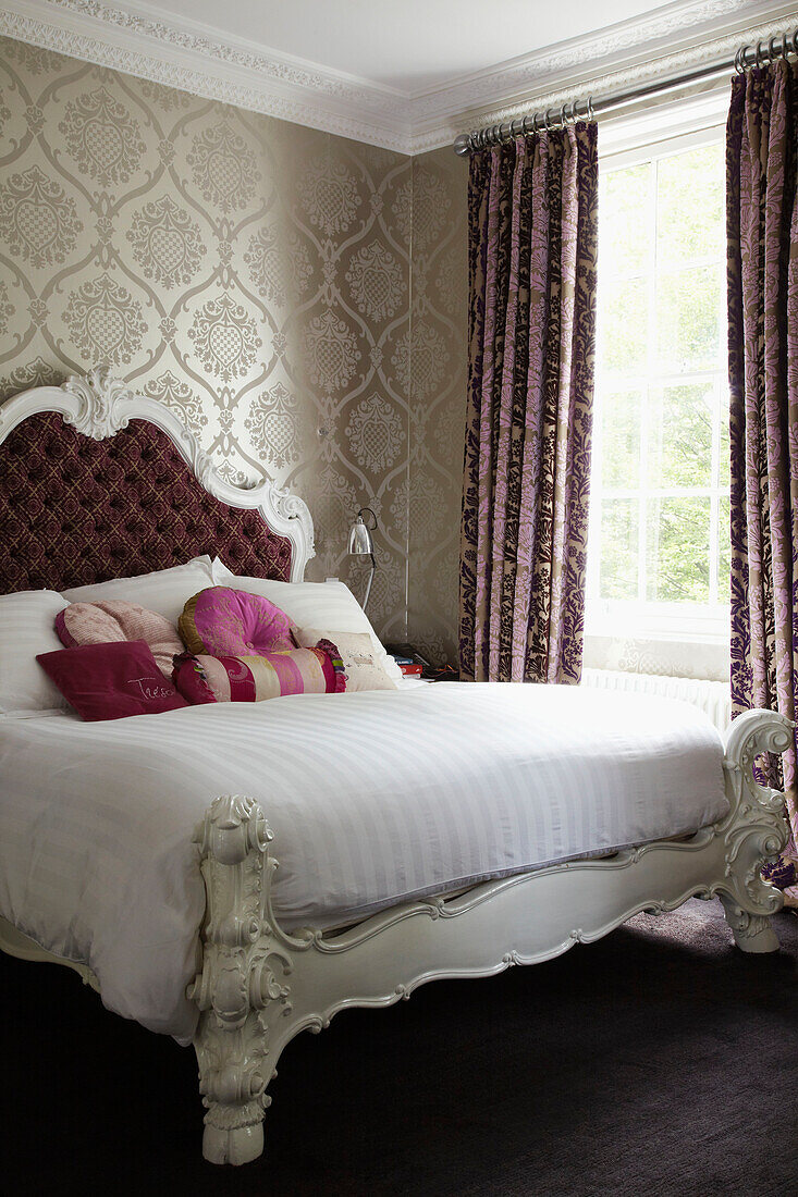 Upholstered headboard on double bed in home of London fashion designer