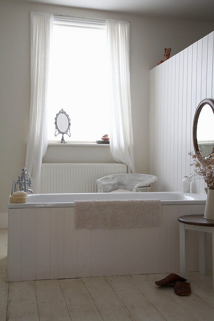 Freestanding bathtub with wood panelling in bathroom