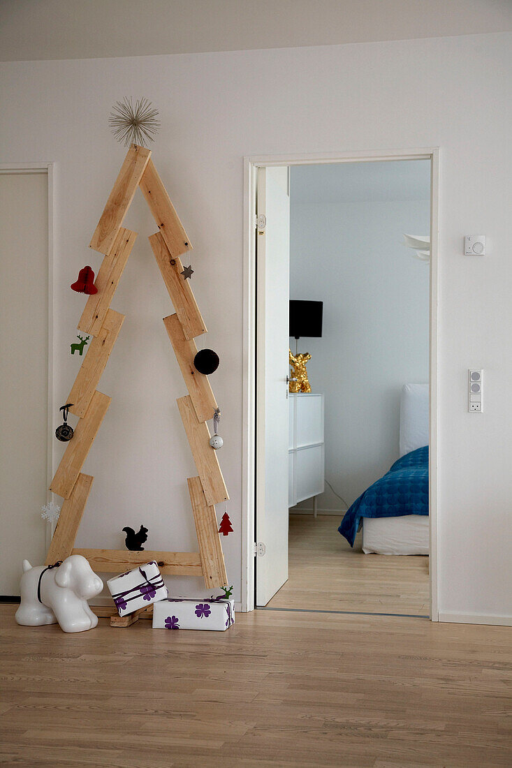 Christmas tree built from wooden planks next to bedroom door