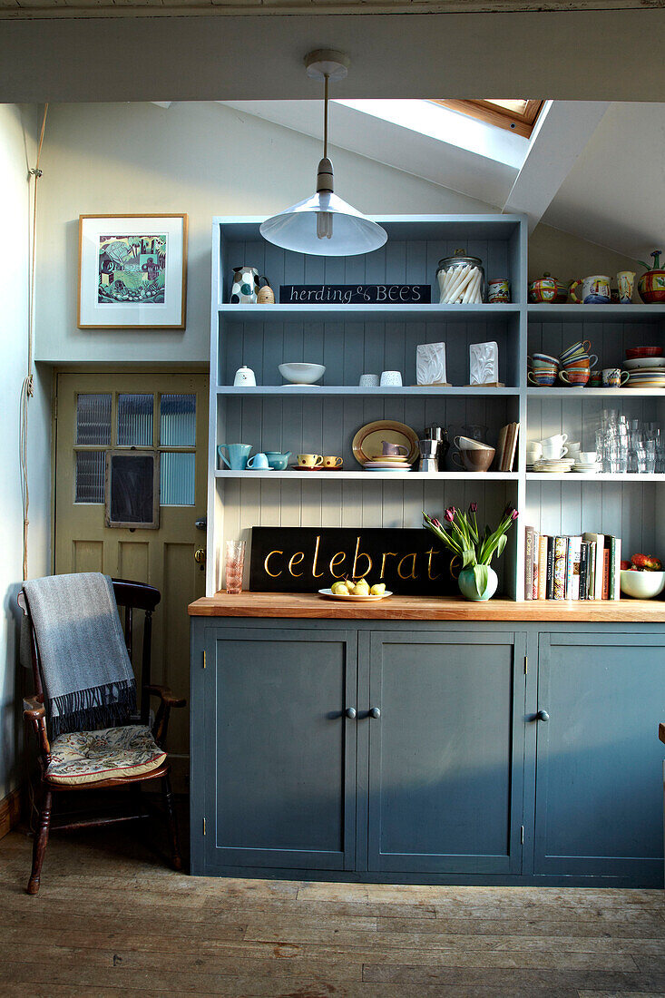 Blaugrün gestrichene Küchenkommode mit dem Schriftzug 'celebrate' in einer Küche in Brighton, Sussex, UK