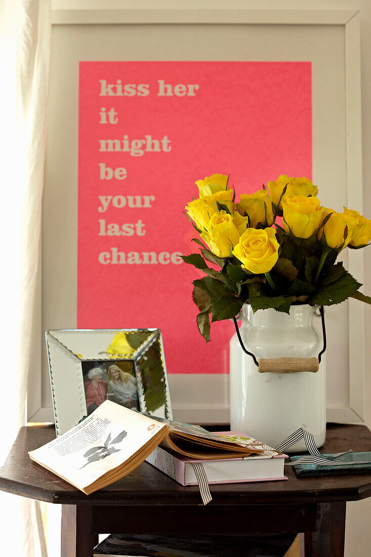 Gelbe Rosen, Bild mit rosa Poesie-Spruch, Bücher und Familienfoto auf einem Beistelltisch
