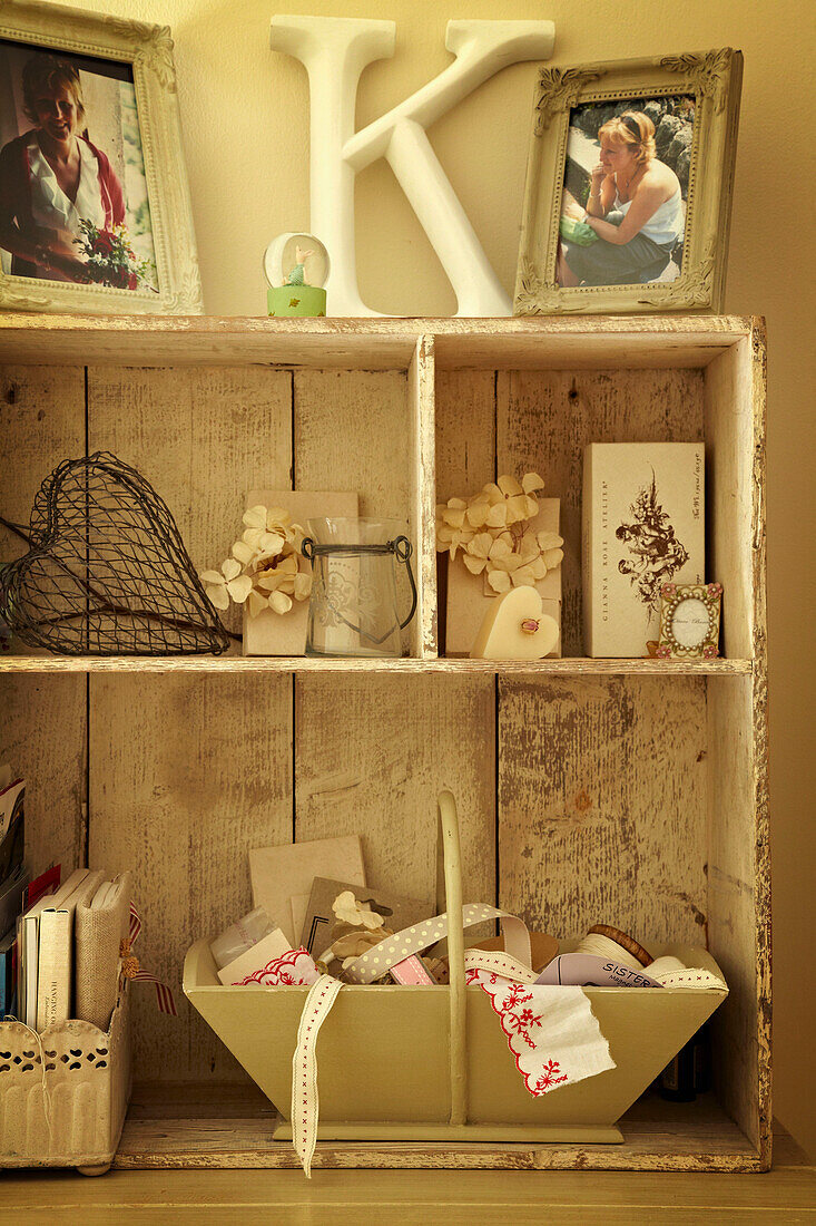 Ornaments and family photographs on salvaged storage cabinet in West Sussex home, England, UK