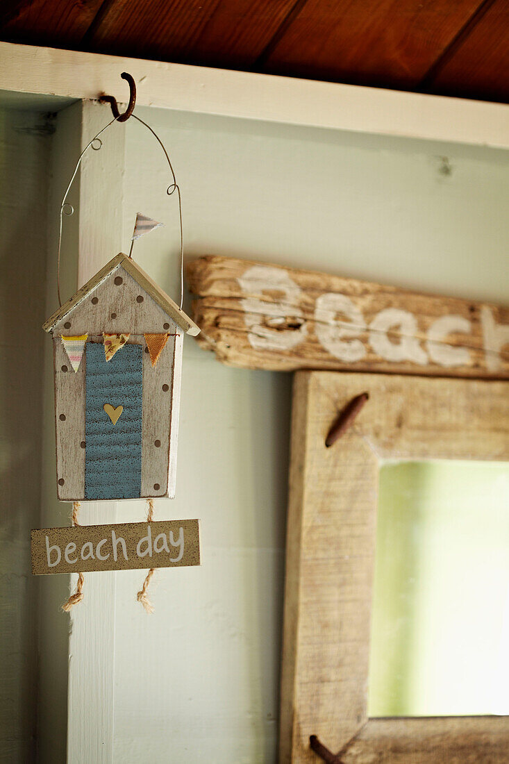 Dekohaus und Treibholz mit dem Schriftzug 'beach' in einer Strandhütte in West Sussex, England, UK