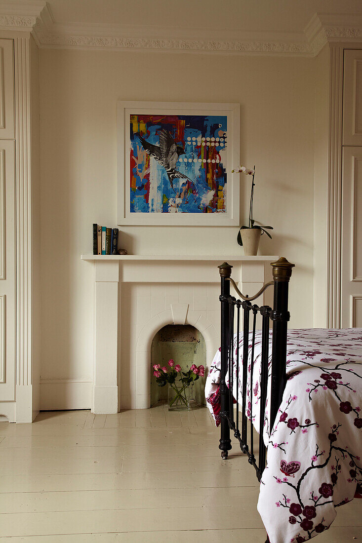 Wrought iron bed and original fireplace in Brighton townhouse, Sussex, England, UK