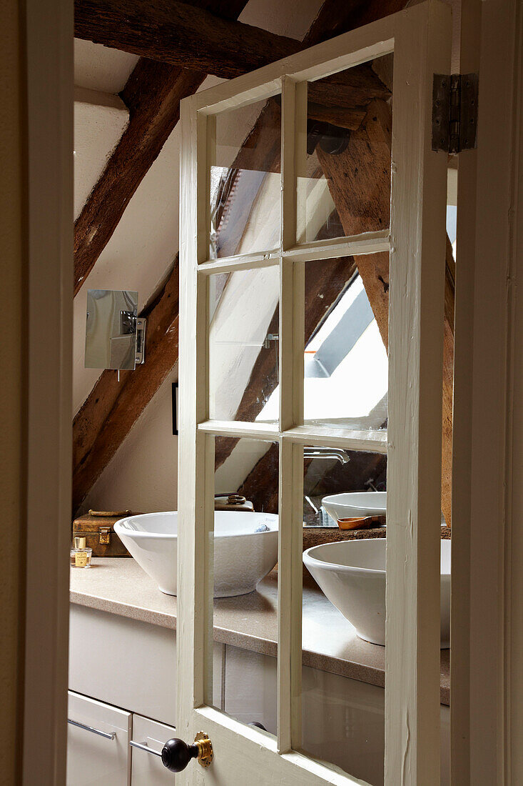 Blick durch die Glastür zum Doppelwaschbecken in einem Haus in West Sussex, England, UK
