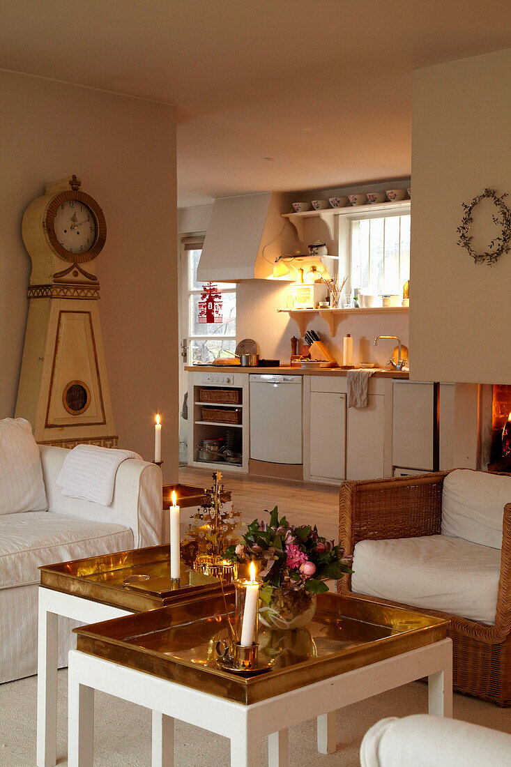 Brennende Kerzen in offener Wohnküche mit skandinavischer Uhr