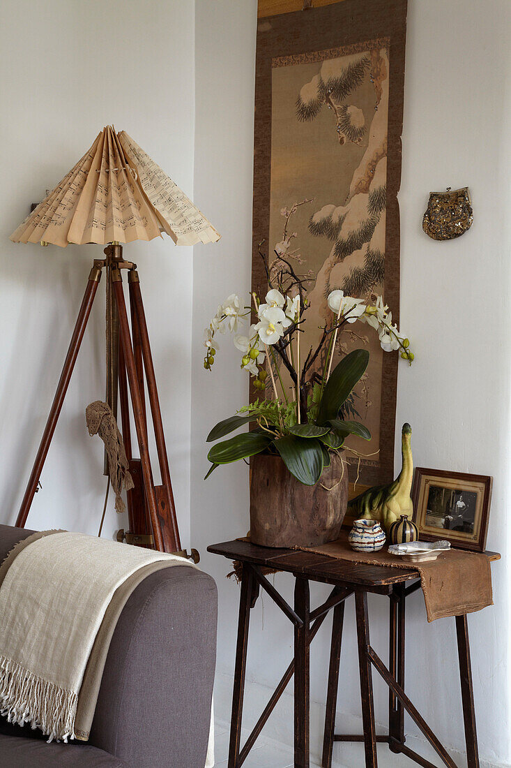 Wandbehang, Orchidee auf Beistelltisch und Dreifußlampe in einem Londoner Haus