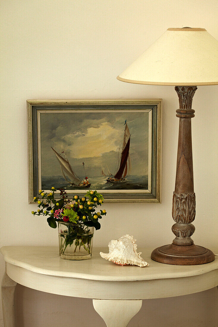 Lamp and cut flowers with artwork in Norfolk beach house, UK