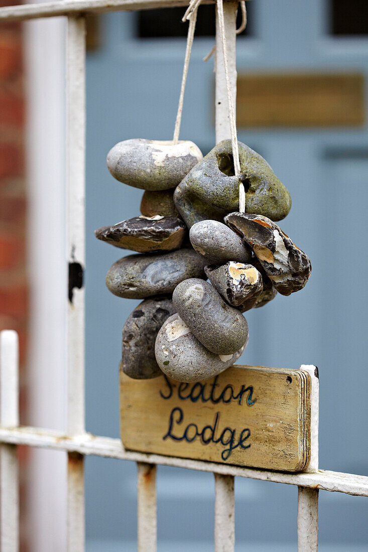 Kieselsteine hängen am Tor eines Strandhauses in Norfolk, UK