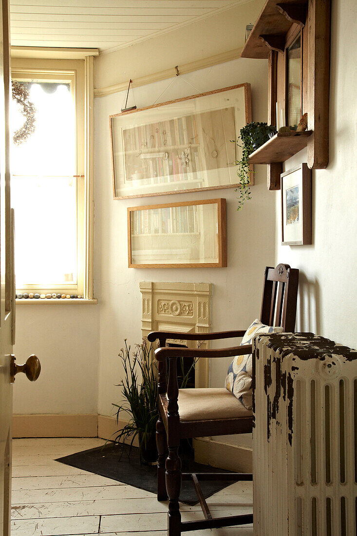 Wooden armchair and radiator with artwork in Brighton home, UK