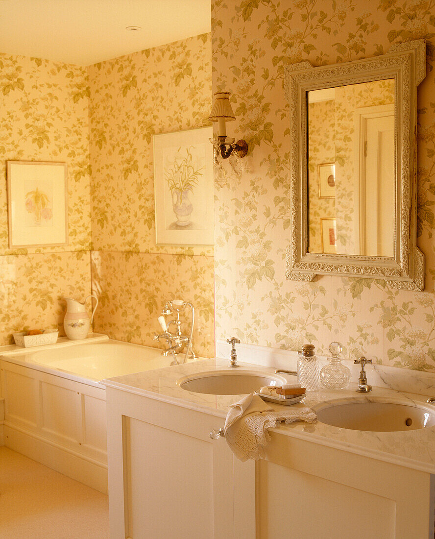 Traditionelles gelbes Badezimmer mit Mustertapete, zwei Waschbecken mit Spiegel und Badewanne