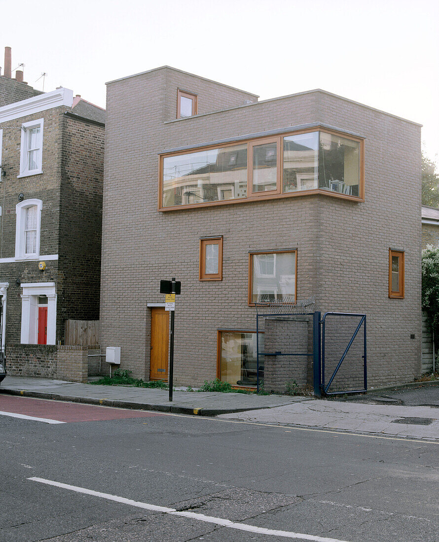 Außenansicht eines modernen quadratischen Gebäudes mit Flachdach und einem großen Fenster übereck