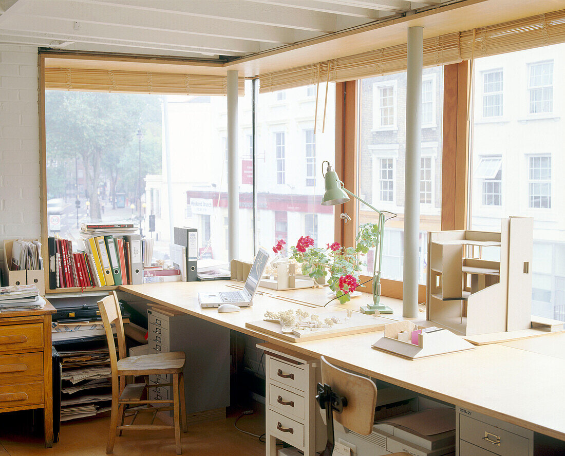 An overview of a home office space with desk in front of a large window that spans the whole room