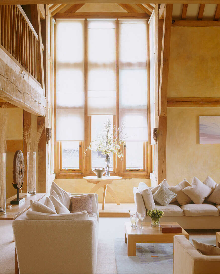 A large window in a converted sitting room with modern soft furnishing beamed ceiling in converted barn