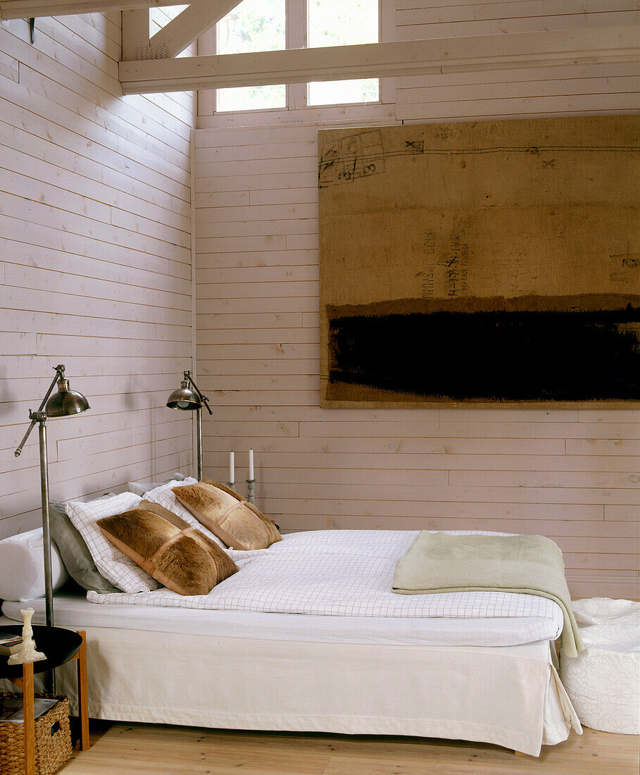 Schlafzimmer im Landhausstil mit hoher Decke und bemalten Holzwänden Gemälde hängt hinter dem Bett