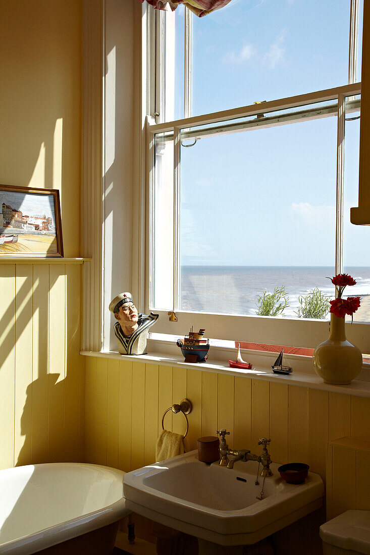 Waschbecken unter einem Fenster im Badezimmer eines Strandhauses in Cromer, Norfolk, England, UK