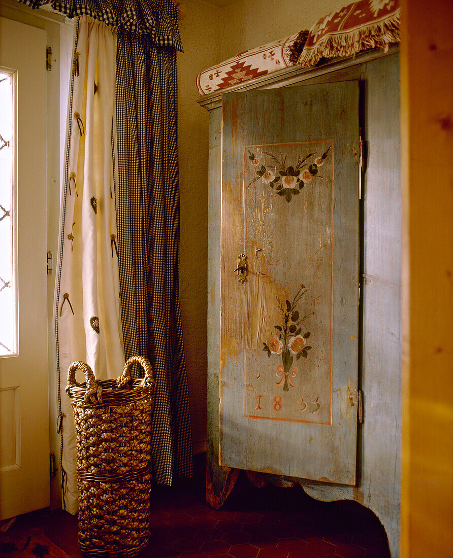 Hallway with antique painted wardrobe and basket by door