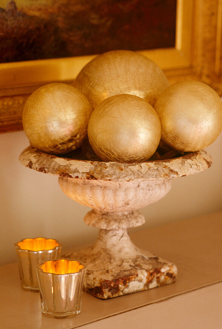 Ein Detail der Weihnachtsschmuck Goldkugeln in Stein Urne beleuchtet Kerzen in Haltern