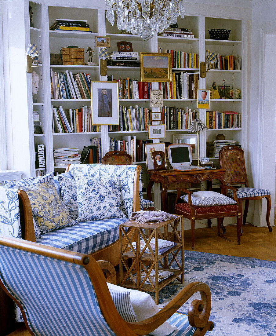 Wooden sofa with blue check fabric in front of book shelves