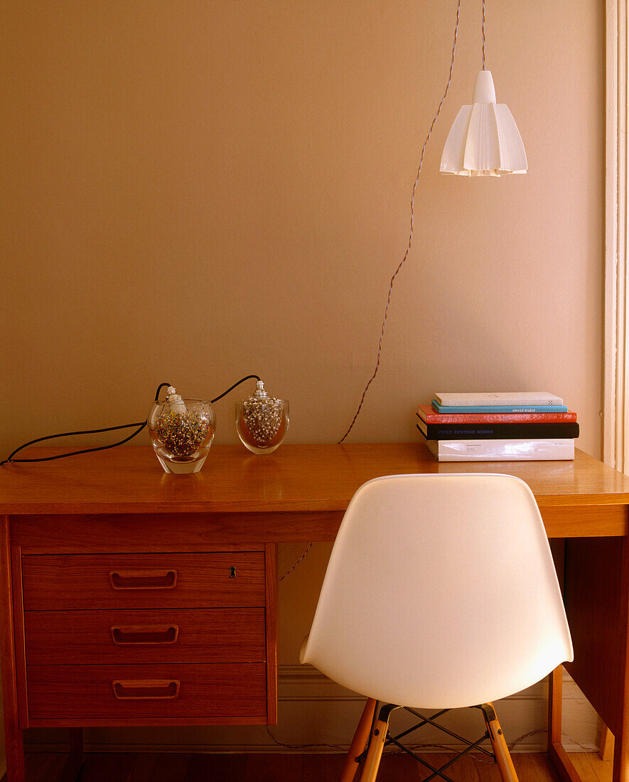 A detail of a modern desk retro chair hanging lamp