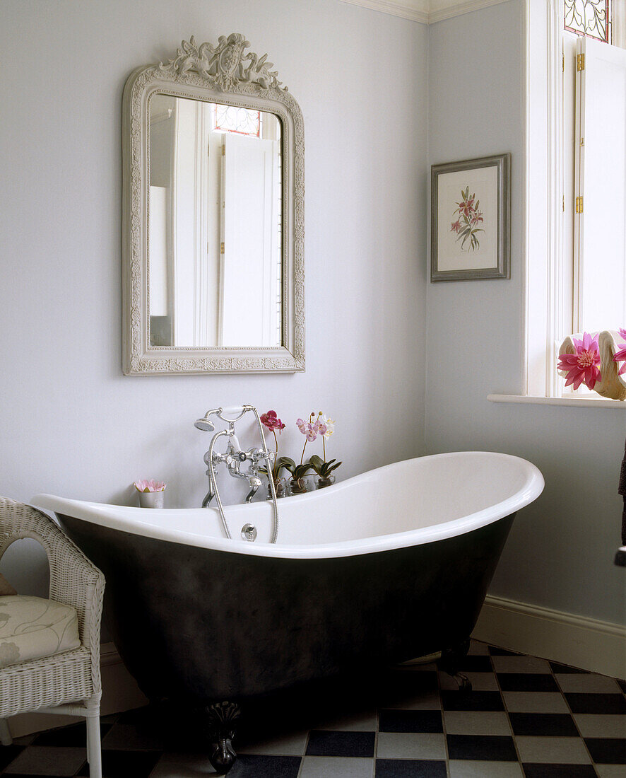 A traditional bathroom with black and white tiled floor