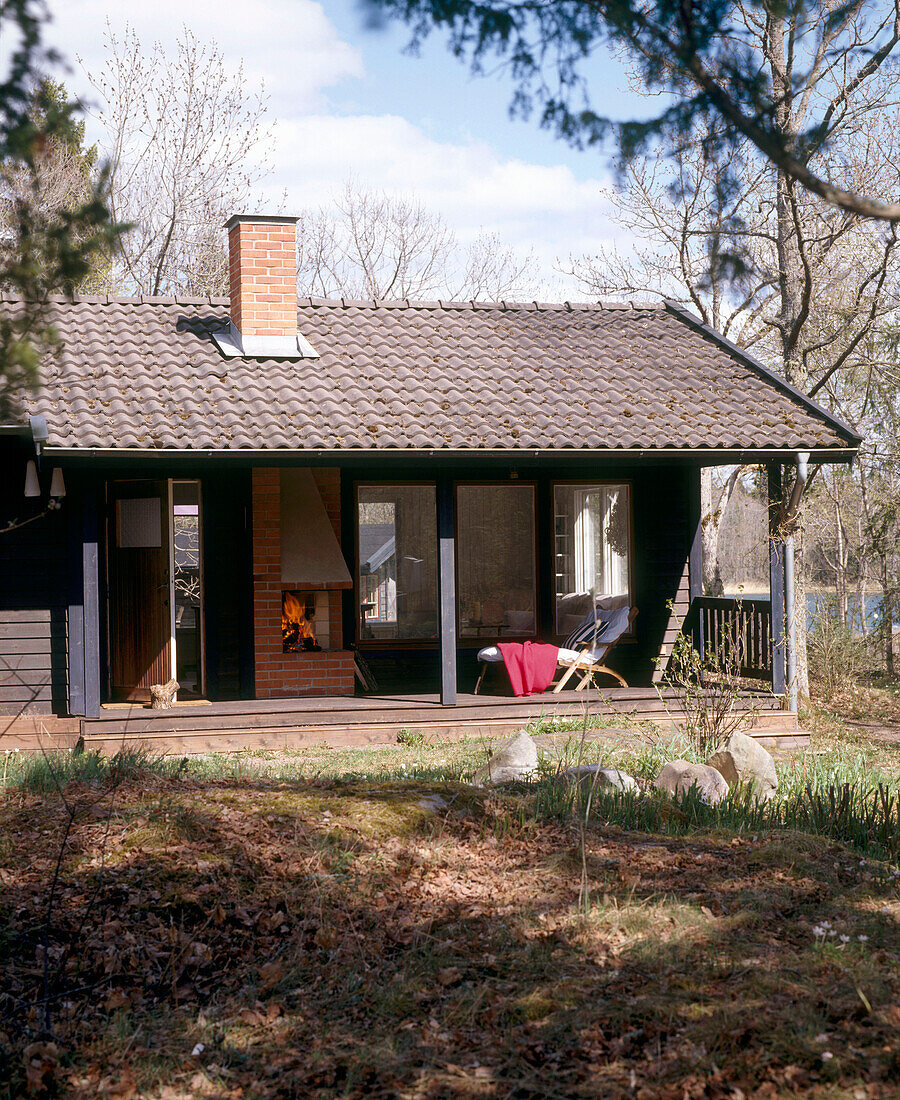 Außenansicht eines traditionellen skandinavischen Sommerhauses aus Holz mit einer Terrasse