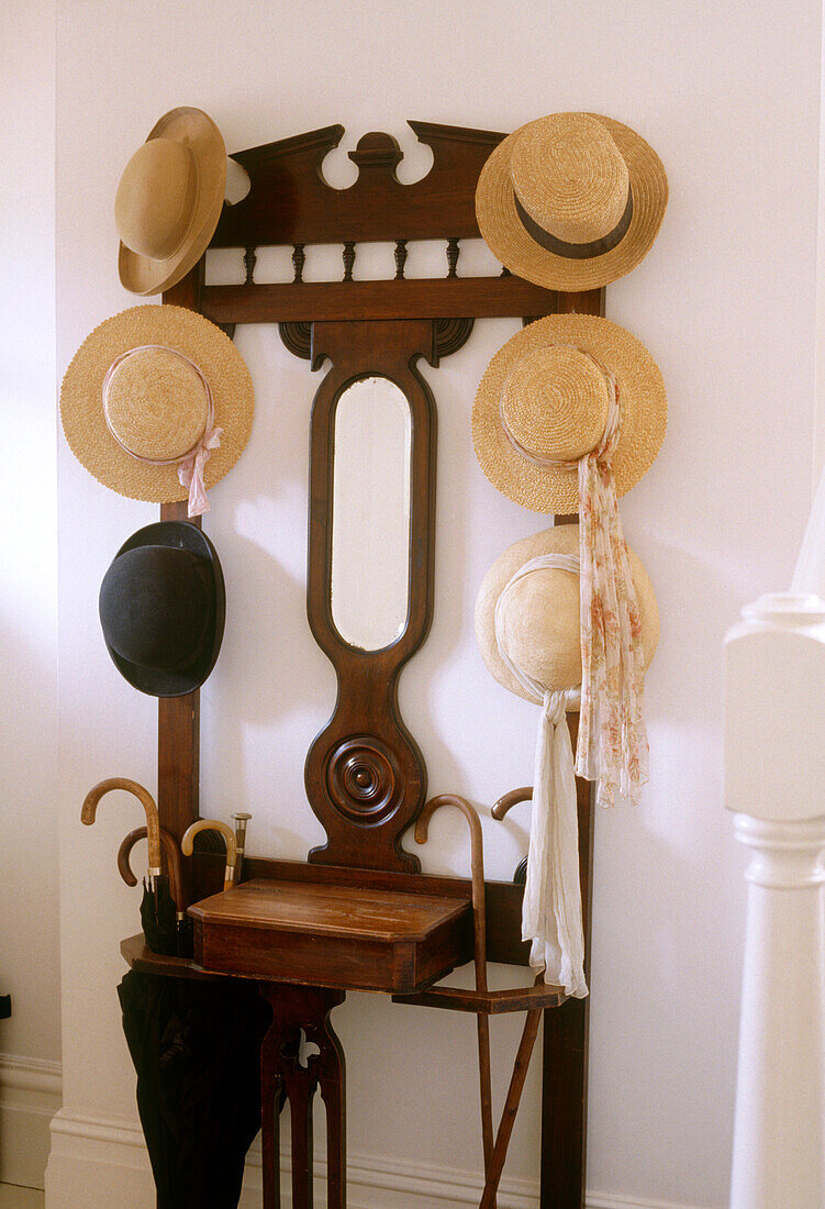 Detail eines traditionellen Hutständers aus Holz mit Platz für Regenschirme an der Unterseite