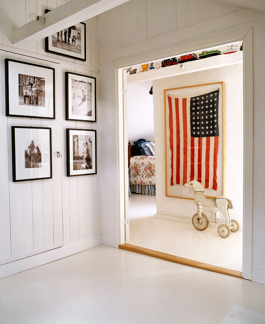 View through open doorway to United States flag hung in frame in hallway