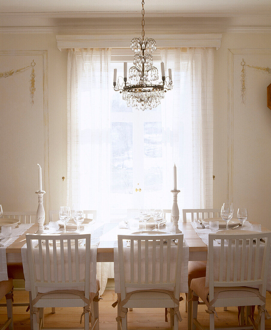 Glaskronleuchter über dem Tisch in einem traditionell skandinavischen Esszimmer