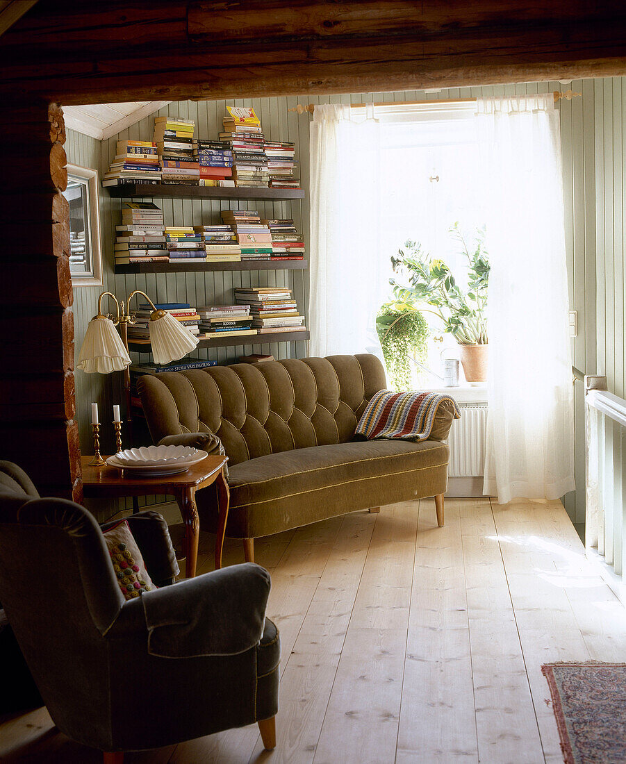 Polstersofa unter einem Regal neben dem Fenster