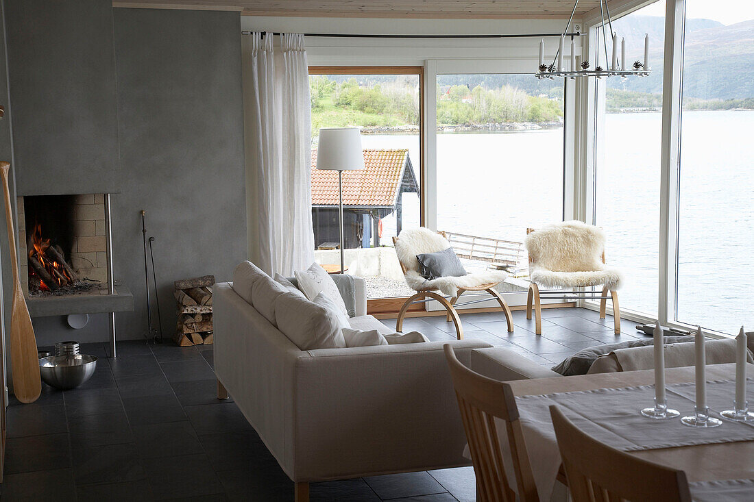Sofa and chairs facing window overlooking lake