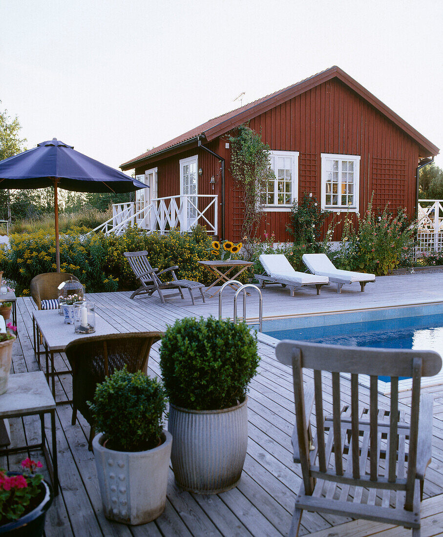 Außenansicht eines Holzhauses mit Garten und Swimming Pool