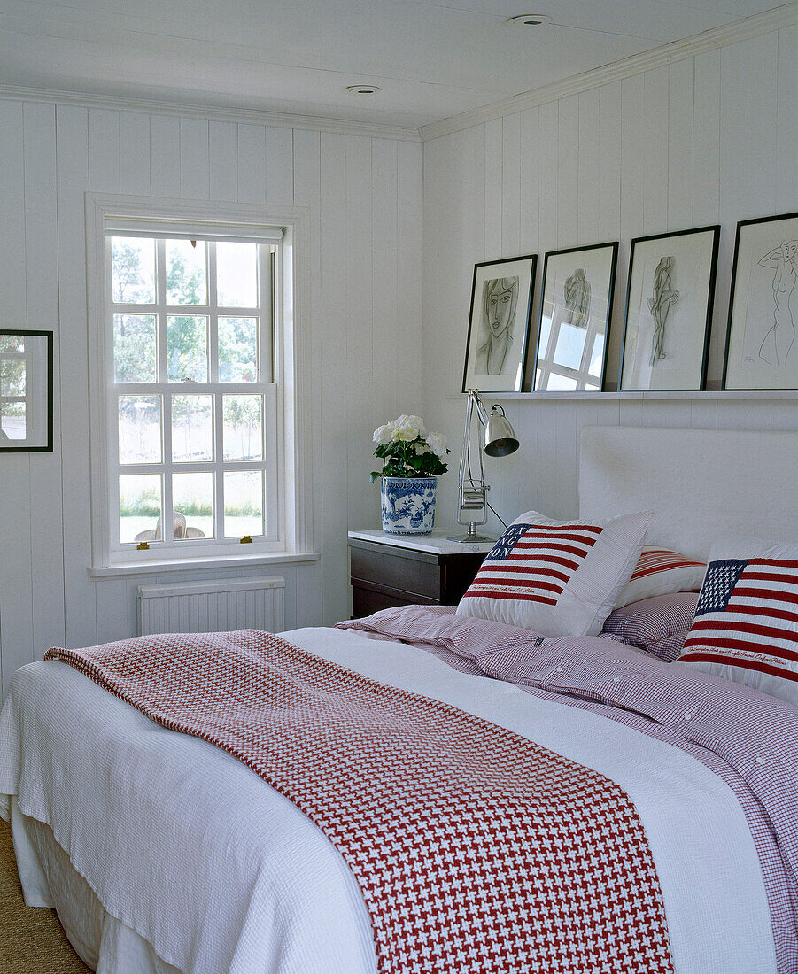 Kissen mit amerikanischer Flagge auf Doppelbett in einem holzgetäfelten Schlafzimmer