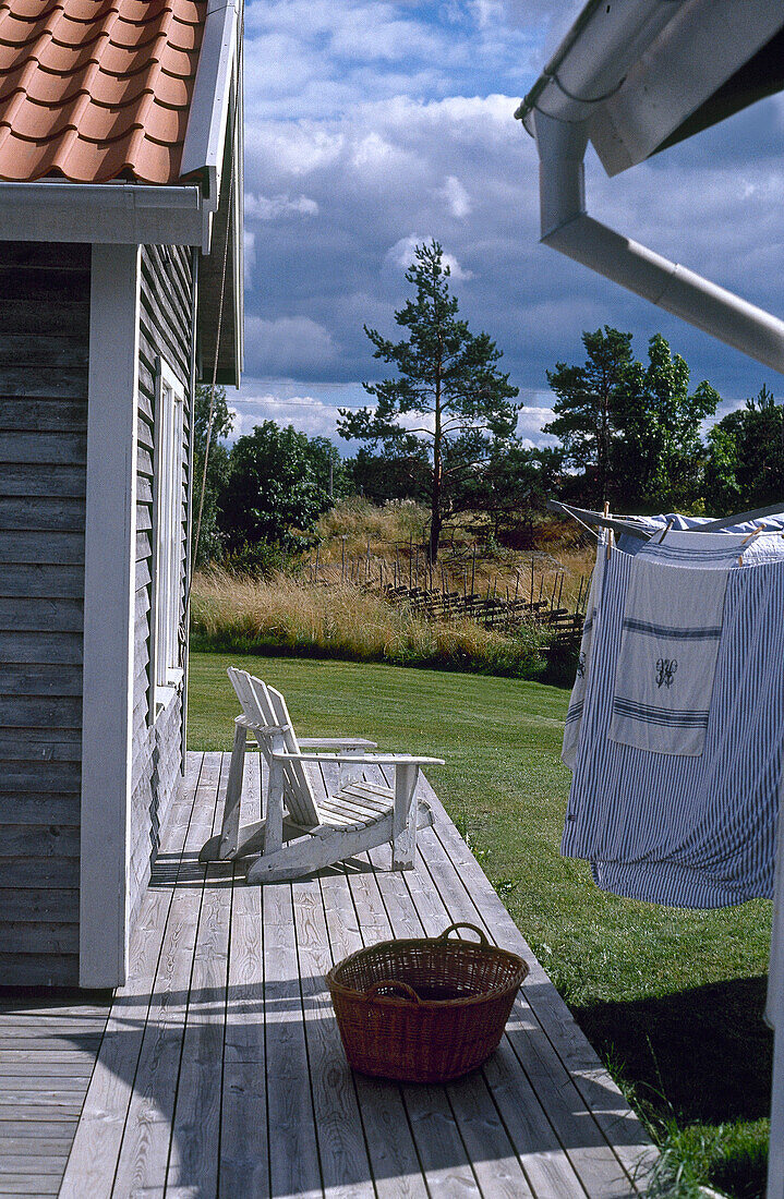 Wooden chair on decked area with washing line to one side