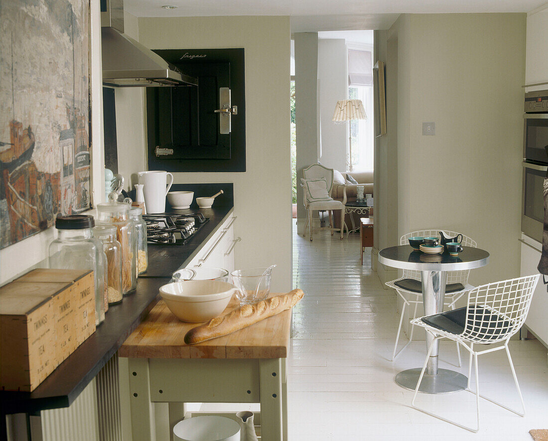 Offene Küche mit rundem Frühstückstisch und Blick durch die Tür zum Sitzbereich