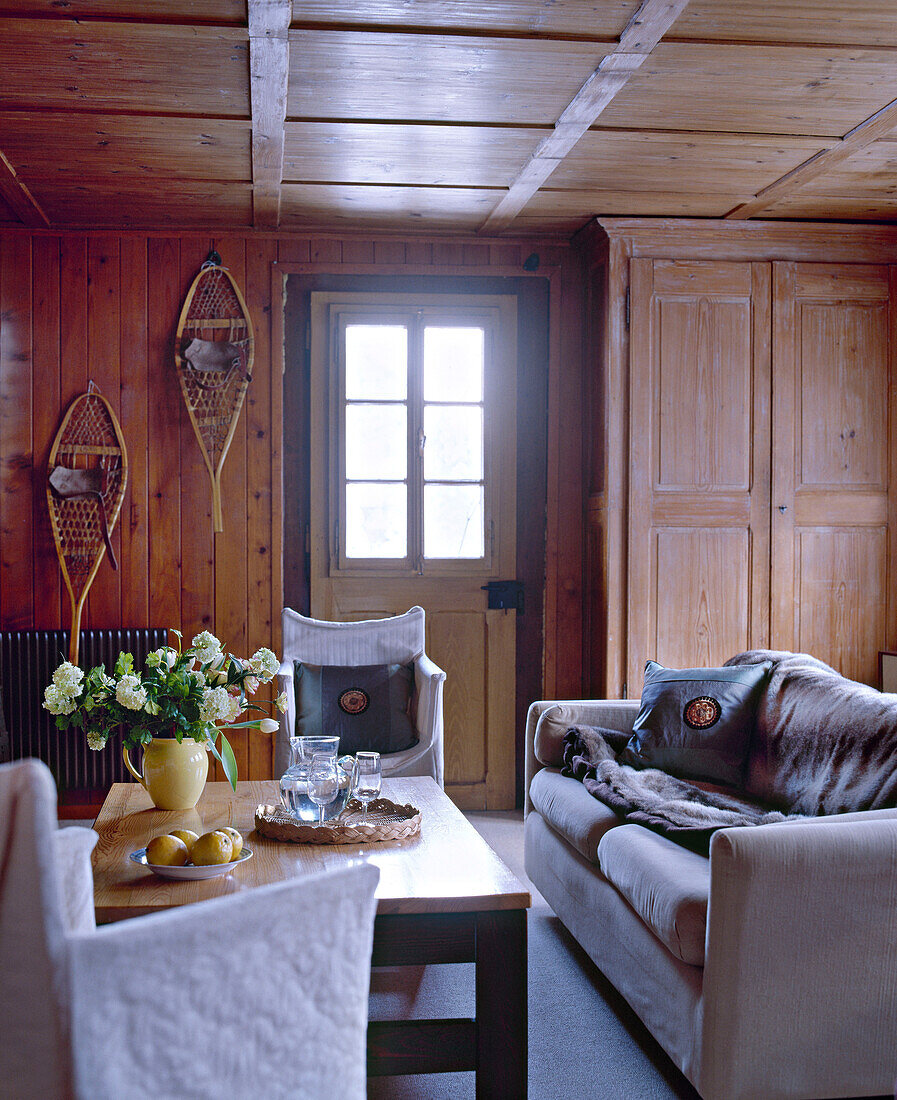 Swiss chalet sitting room with wood panelling and sofa and coffee table