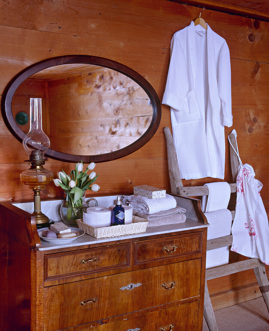 Schweizer Chalet-Schlafzimmer mit Holzvertäfelung und antiker Marmorkommode