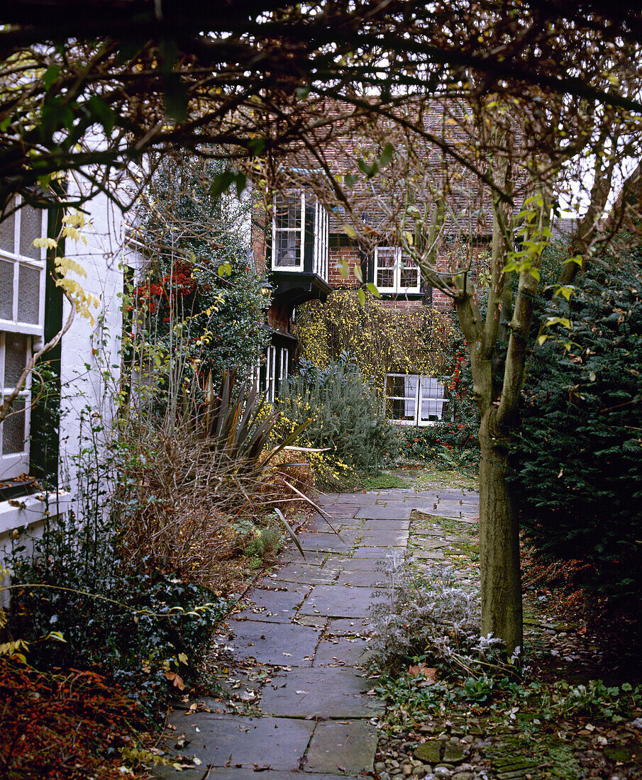 Außenansicht eines freistehenden, weiß getünchten Landhauses mit Garten