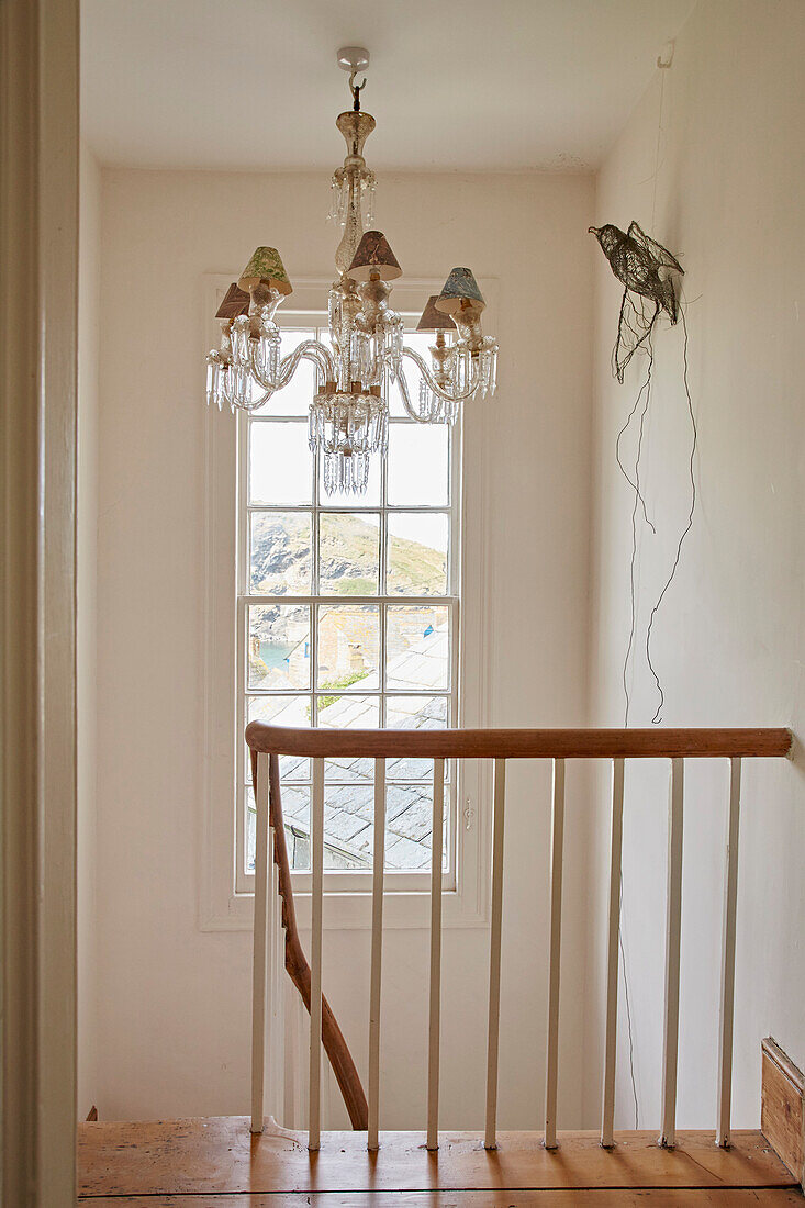 Glass chandeliers and bird ornament with wooden banister in Port Issac beach house Cornwall