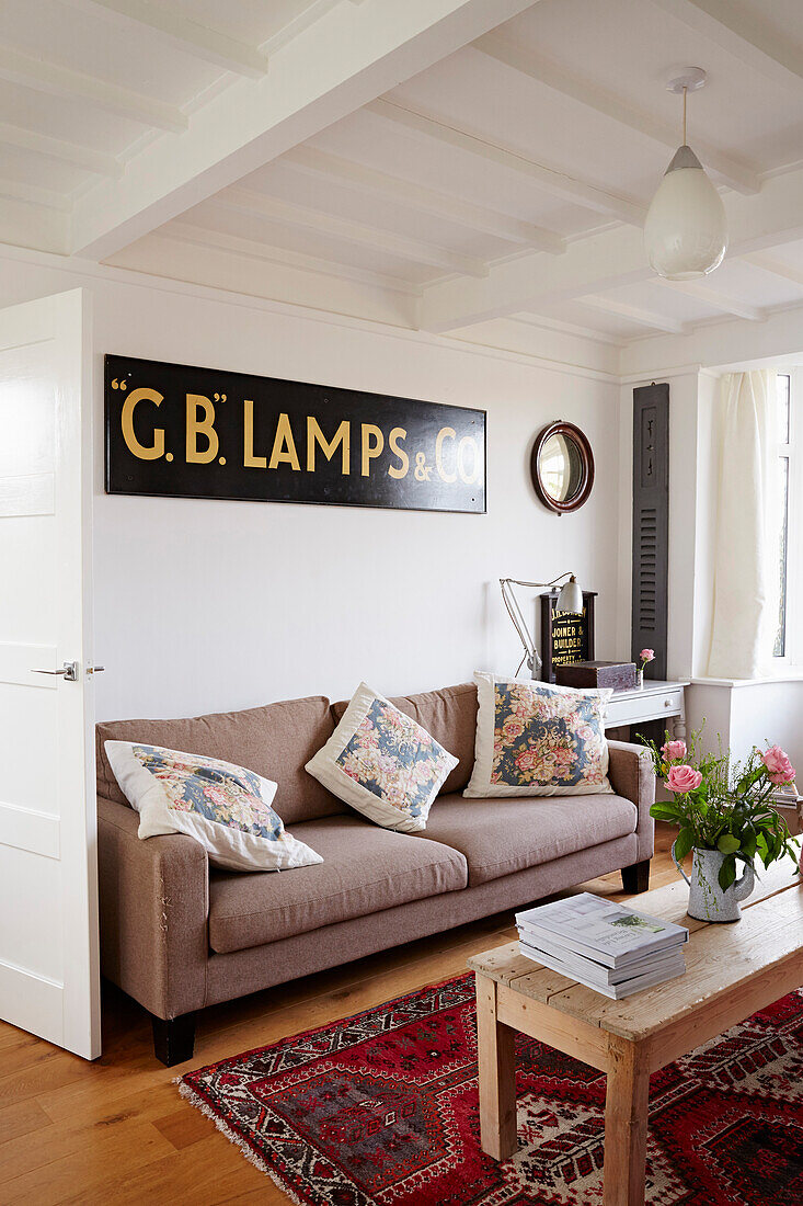 Vintage lamp sign above sofa with wooden coffee table Shoreham by Sea, West Sussex, UK