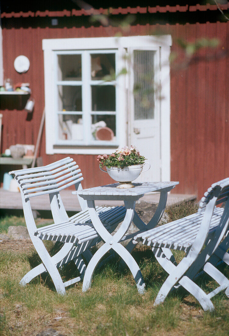 Garden table and chairs on the grass in front of the house