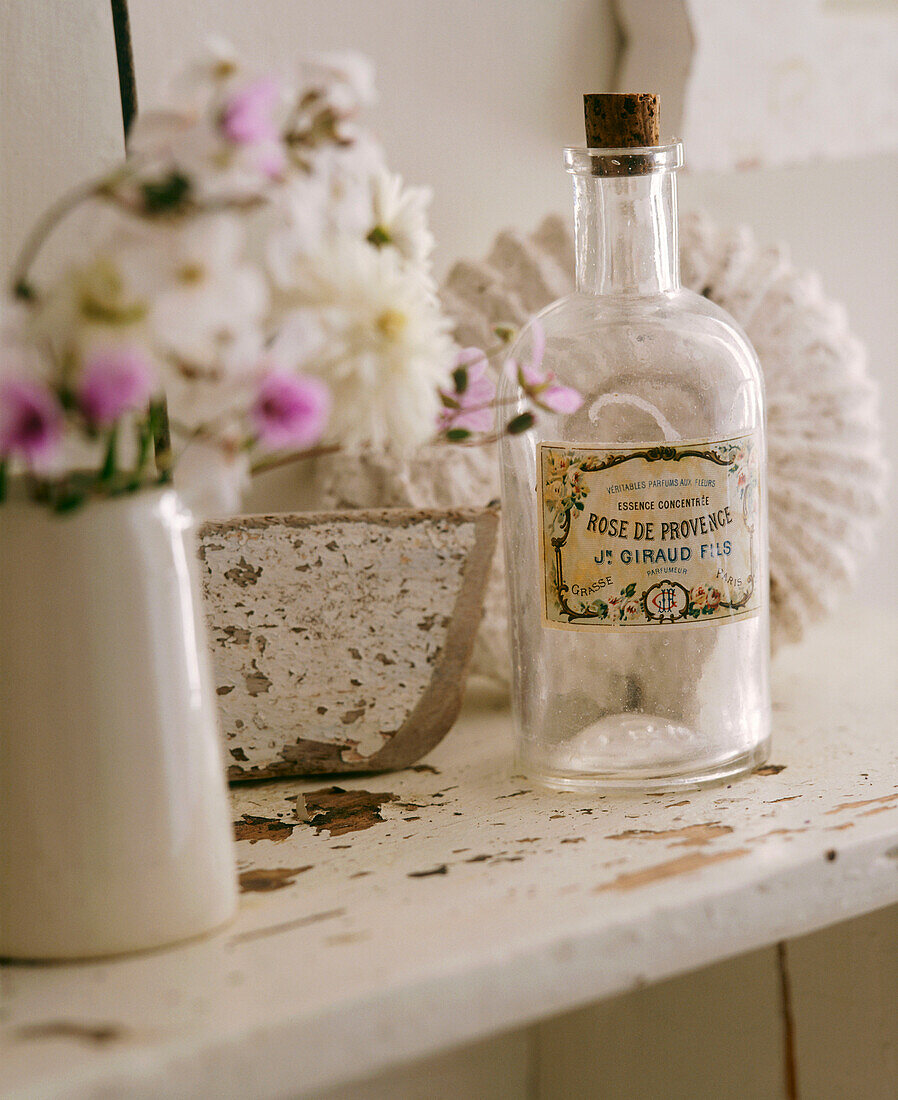 Badezimmer im Landhausstil mit antiker Duftflasche und Blumen auf Regal