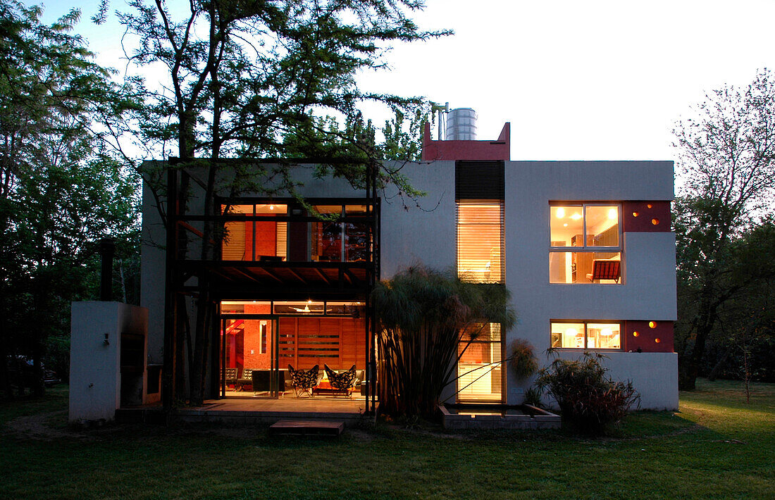 Argentinian cube house covered in brick coloured textured materials with an overhead water tank