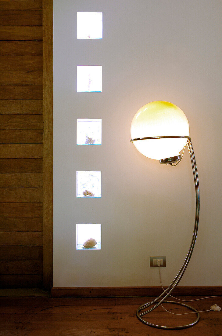 Wohnzimmer mit Glasbausteinen, in die Muscheln eingelassen sind, und beleuchteter Kugelsternlampe